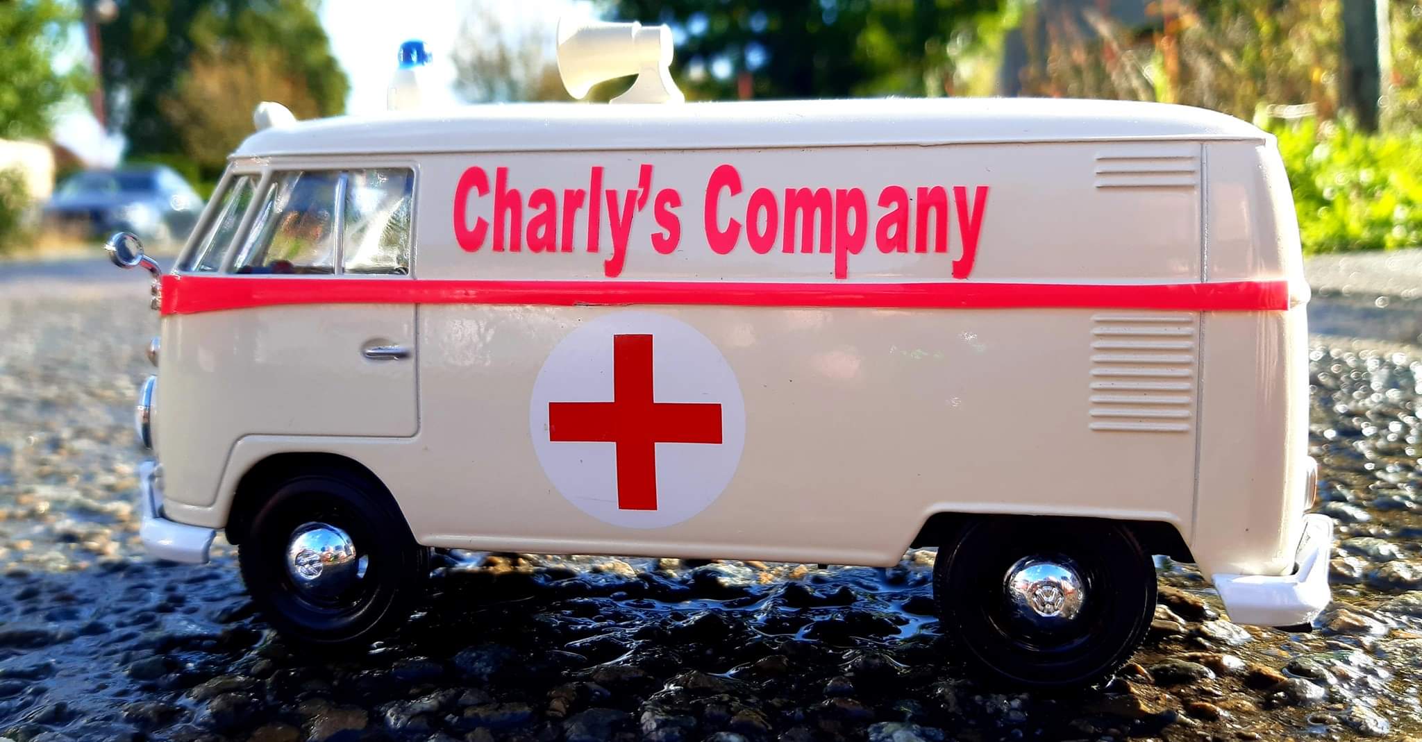 Photo d'une ancienne ambulance rouge et blanche avec une croix médicale sur le côté.